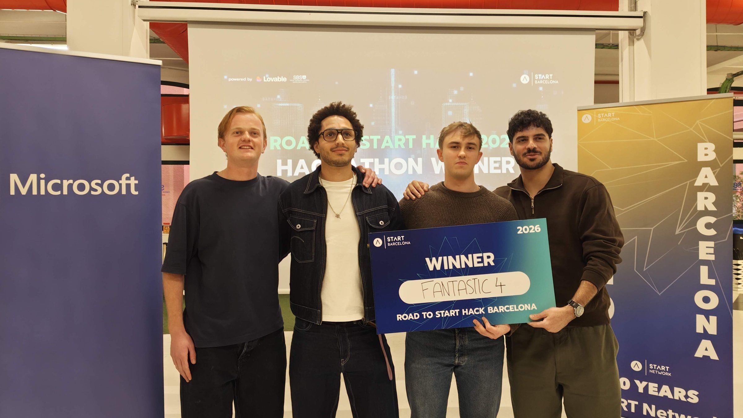 The winning team holding a 'Winner' cheque next to a Microsoft banner