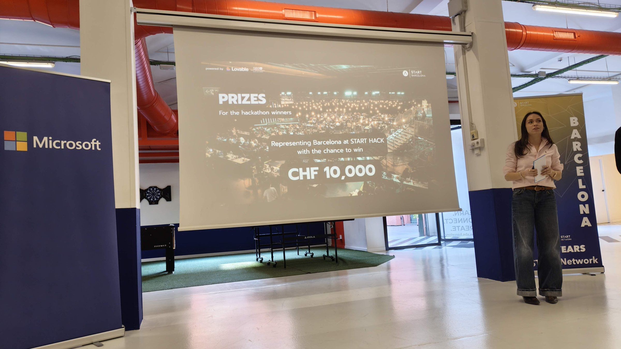 The host presenting the prizes next to a Microsoft banner, 'CHF 10,000' on the screen for the team that goes to START Hack
