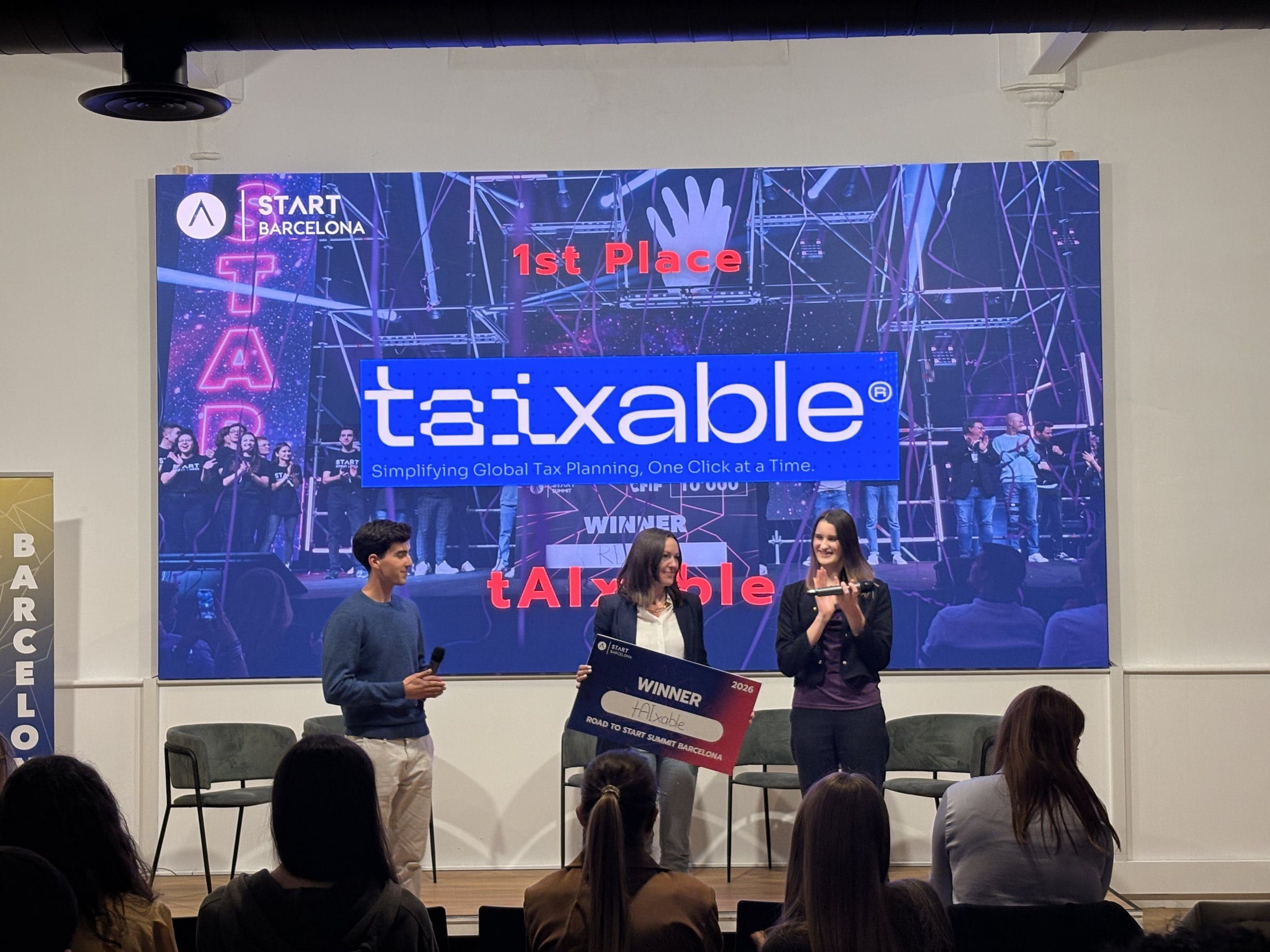 The winning team of Road to START Summit 2026 on stage with their prize, '1st Place' on the screen behind them