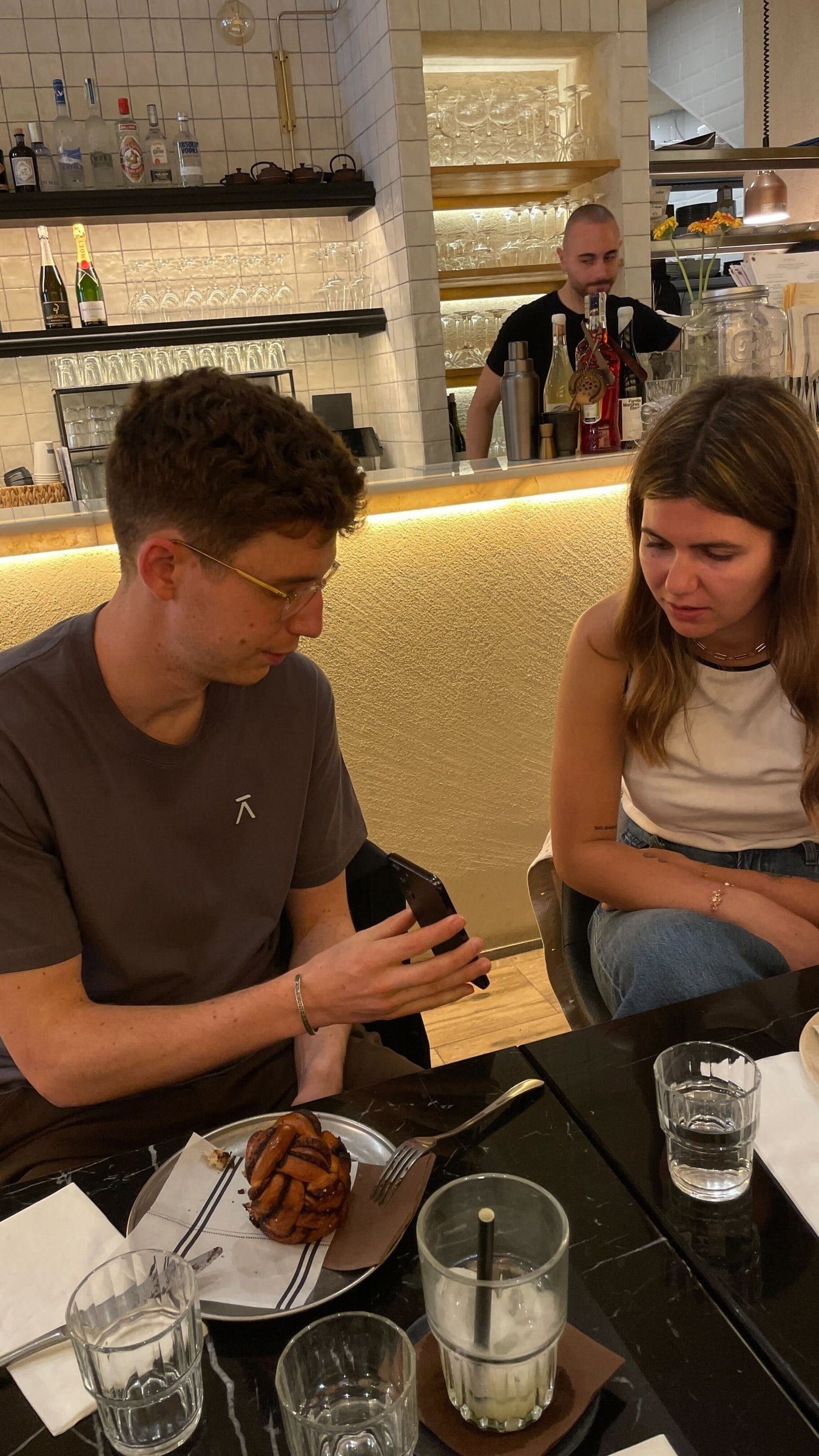 A member talking with the founder of Balance Phone over dinner at a restaurant bar