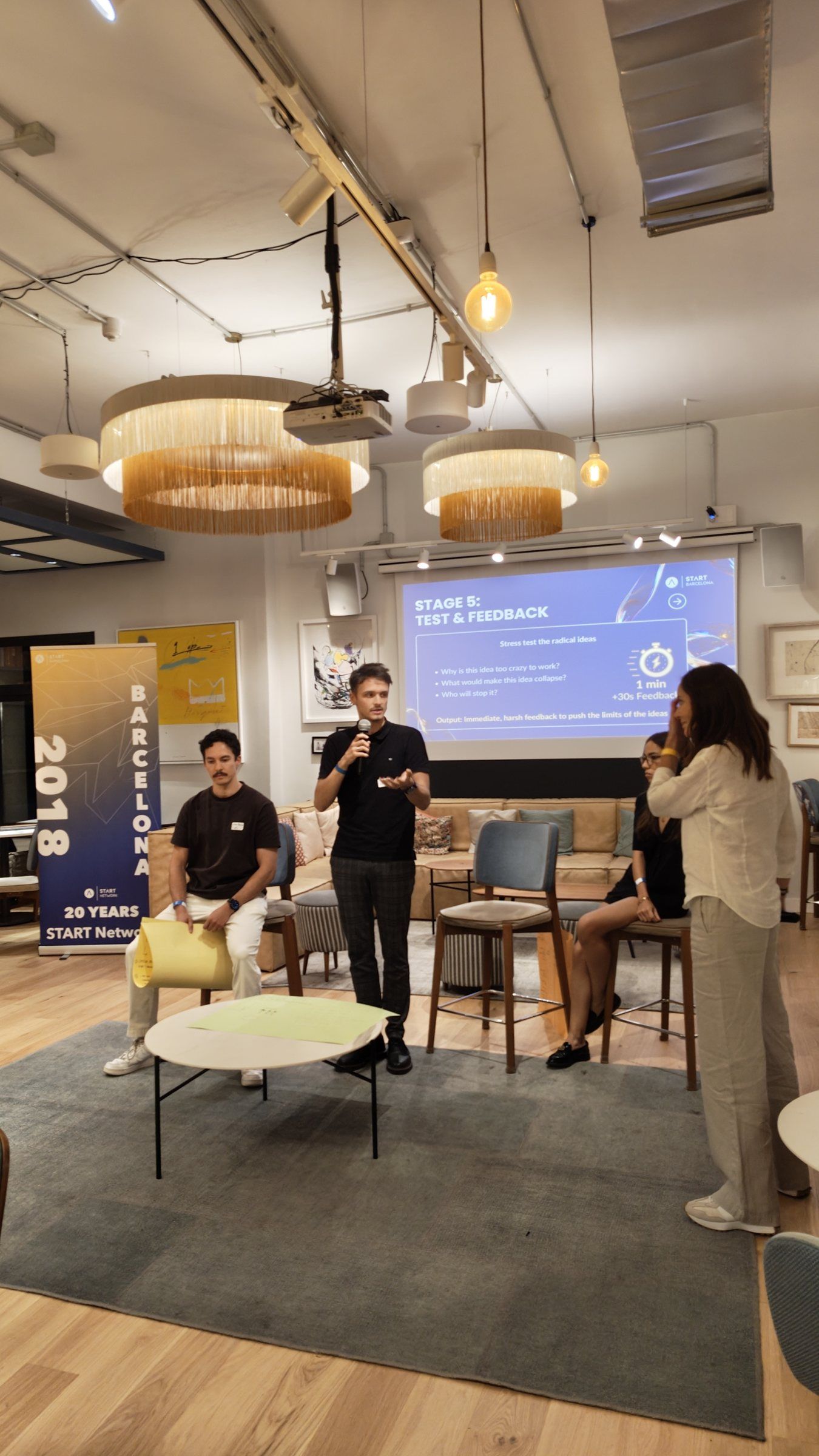 A participant presenting to the room next to the START Barcelona banner